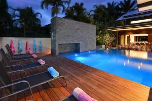una piscina con tumbonas junto a una casa en 6 Beachfront Mirage - Luxury 4 Bedroom Home, en Port Douglas