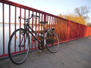 een fiets geketend aan een hek op een brug bij Country house on the Priepertsee in Priepert