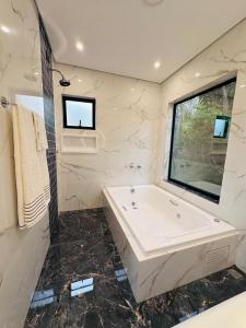 a bathroom with a large tub and a window at Cabana Sabá in Ibiúna +27 photos