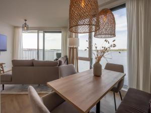una sala de estar con una mesa y un sofá en Apartment Veerse Meer with Private Marina, en Arnemuiden