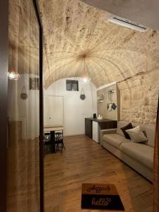 a living room with a couch and a stone wall at La Maison di Serena in Bari +21 photos