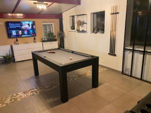 a pool table in a living room with a tv at Dépendance avec Billard à proximité Zénith Rouen in Le Grand-Quevilly