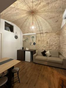 a living room with a couch and a stone wall at La Maison di Serena in Bari