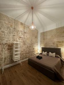a bedroom with a bed and a brick wall at La Maison di Serena in Bari