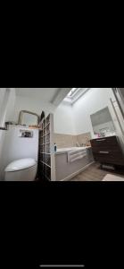 La salle de bains est pourvue de toilettes blanches et d'un lavabo. dans l'établissement Dépendance avec Billard à proximité Zénith Rouen, à Le Grand-Quevilly