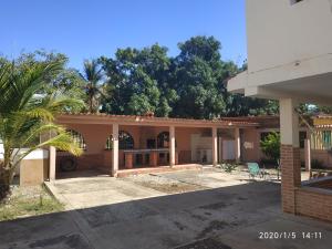 una casa con una palma di fronte di Tú Casa de playa La Milagrosa a Boca de Uchire