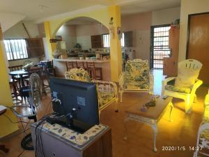 sala de estar con sillas y TV. en Tú Casa de playa La Milagrosa en Boca de Uchire