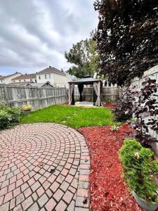 a brick walkway in a backyard with a gazebo at B’s King Suite in Ottawa