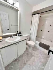 a bathroom with a sink and a toilet and a mirror at B’s King Suite in Ottawa