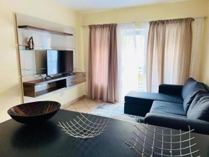 a living room with a blue couch and a tv at Karabo Spaces in Midrand