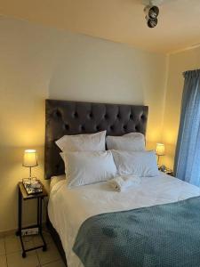 a bedroom with a large bed with white sheets and pillows at Karabo Spaces in Midrand