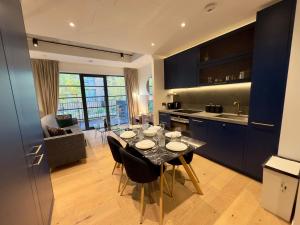 Amazing Cosy Apartment, Next to O2 Arena and close to London Excel, Secure Parking في لندن: مطبخ وغرفة طعام مع طاولة وكراسي