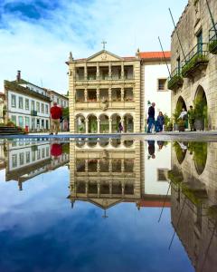 a reflection of a building in the water at Altamira Studio in Viana do Castelo