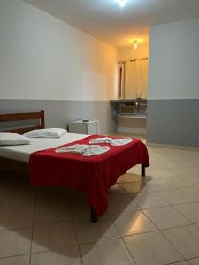 una camera da letto con un letto con una coperta rossa sopra di Hotel Pousada Em Guarapari - Pousada Paraiso a Guarapari