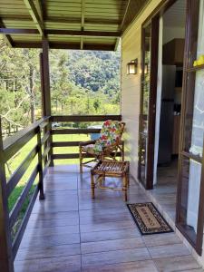 a screened porch with a chair and a table at CASAS DE CAMPO MOZZAFIATO in Urubici