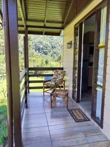 a porch with a bench and a chair on it at CASAS DE CAMPO MOZZAFIATO in Urubici