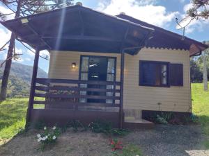 a tiny house with an awning in a field at CASAS DE CAMPO MOZZAFIATO in Urubici