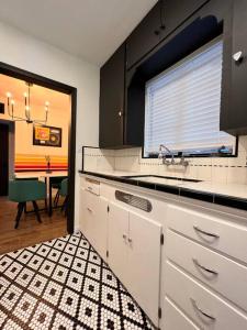 una cocina con armarios blancos, una ventana y una mesa en Casa De Rock, en Tucson
