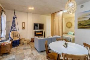 een woonkamer met een tafel en een slaapkamer bij Cipressi Spectacular Italian Tuscan style loft in Santeagueda