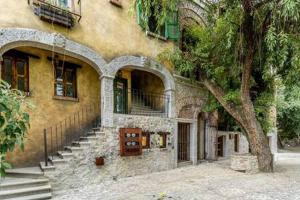 um edifício com escadas e uma árvore em frente em Cipressi Spectacular Italian Tuscan style loft em Santeagueda