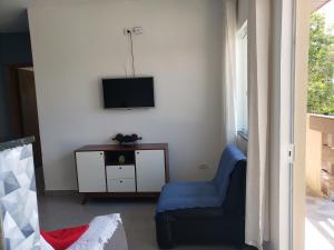 een woonkamer met een blauwe stoel en een tv bij Residencial Mineiro in Itapoa