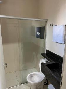 a bathroom with a toilet and a glass shower at Apartamento Boa Vista in Garanhuns