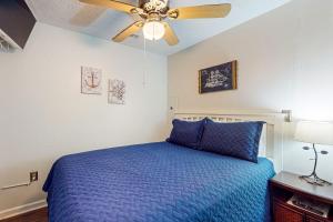 a bedroom with a blue bed and a ceiling fan at La Mirage 302 in Myrtle Beach