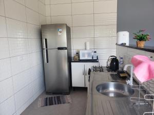a kitchen with a stainless steel refrigerator and a sink at Residencial Mineiro- apartamento de 02 quartos in Itapoa