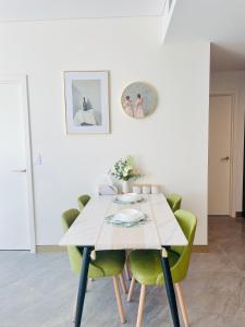 una mesa de comedor con sillas verdes en una habitación en Modern Apartment St Leonards, en Sídney