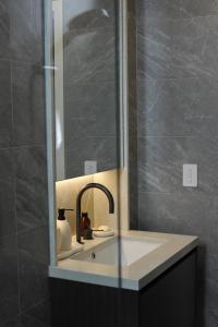 a bathroom with a sink and a mirror at Modern Apartment St Leonards in Sydney