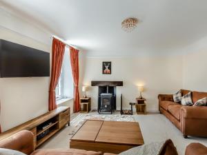 a living room with a couch and a fire place at Cartmel Place in Cartmel