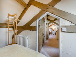 a attic room with a bed and wooden beams at Cartmel Place in Cartmel