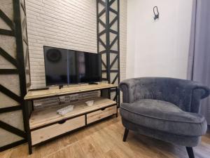 a living room with a chair and a television at Exclusividad a Pie de la Torre de la Catedral in Granada