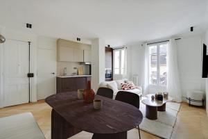 a living room with a table and a kitchen at CHATEAU DE VINCENNES Luxury Flat from 5 min to Paris in Vincennes