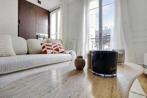 a living room with a white couch and a large window at VINCENNES Luxury flat L005 in Vincennes