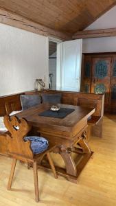 a wooden table and a chair in a room at Alte Villa Traunstein in Traunstein