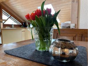 un vaso di tulipani rossi seduto su un tavolo di Alte Villa Traunstein a Traunstein