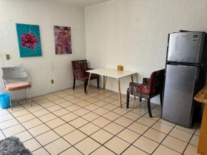um quarto com uma mesa e cadeiras e um frigorífico em Habitación privada en casa de huespedes em Guadalajara