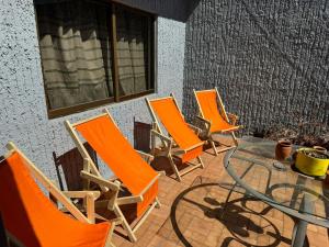 a group of chairs and a glass table on a patio at Habitación privada en casa de huespedes in Guadalajara