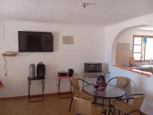 d'une salle à manger avec une table et une télévision murale. dans l'établissement Hostal el rancho, à San Pedro de Atacama