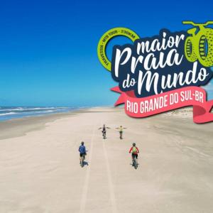 a group of people riding bikes on the beach at Casa de Praia Extremo Sul in Rio Grande