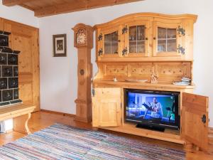 sala de estar con TV y reloj de pie en Ferienhaus Lois & Lisl, en Schleching