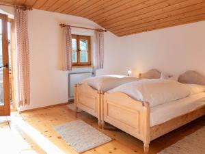 Un dormitorio con una cama de madera en una habitación. en Ferienhaus Lois & Lisl, en Schleching