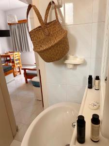 - Baño con lavabo y cesta en la pared en EFFIE'S STUDIOS, en Alinda