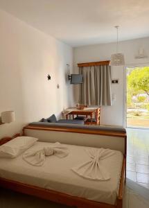 a bedroom with a bed and a table and a window at EFFIE'S STUDIOS in Alinda
