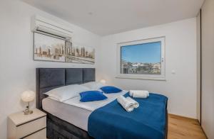 una camera da letto con un letto grande con lenzuola blu di Apartments by the sea Vantacici, Krk - 21690 a Malinska