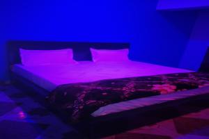 a bed in a room with purple lighting at OYO Hotel Rosewood in Palwal
