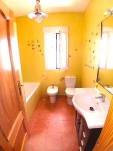 ein gelbes Badezimmer mit einem WC und einem Waschbecken in der Unterkunft El Mirador de Pablo, casa con patio privado in Alomartes