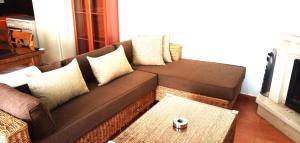 uma sala de estar com um sofá castanho com almofadas em El Mirador de Pablo, casa con patio privado em Alomartes