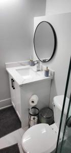 uma casa de banho com um lavatório branco e um espelho. em Scarborough New 2-Bedroom Basement em Toronto